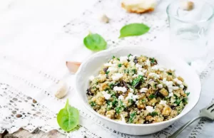 Warmer Quinoa-Salat mit Gemüse, Kichererbsen und Walnüssen in einer Schale